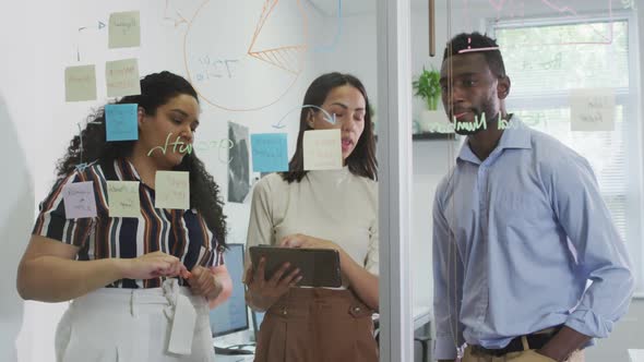 Focused diverse group of business people working together, brainstorming in modern office