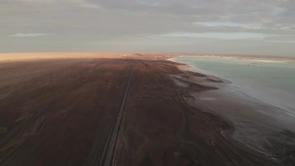 Straight road by the salt lake with wide flatlands background