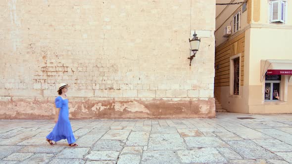 Attractive girl walking by the wall in Split, Croatia