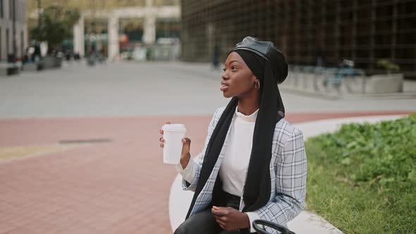 Muslim Woman Drinking Coffee on Street