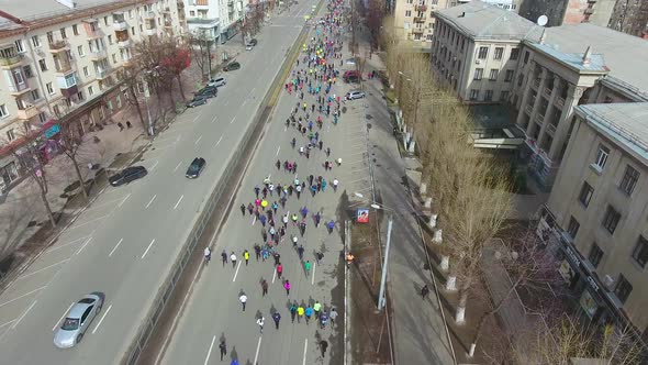 Many People Running Marathon Competition through the Roads of City