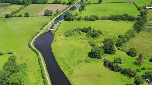 Aerial view over an English canal going through a green countryside setting