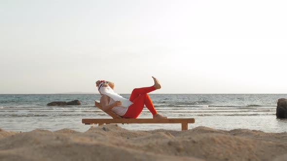 Funny Santa Claus Sunbathes. Santa Lies on Wooden Lounger on Beach By the Sea and Drinks a Delicious