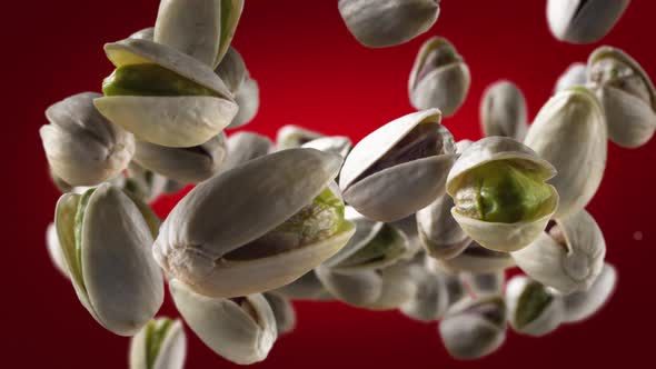 Flying of Pistachios in Deep Red Background