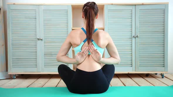 Young Teenager Female Fit Instructor Practicing Yoga Sitting with Namaste Behind Back Full Shot