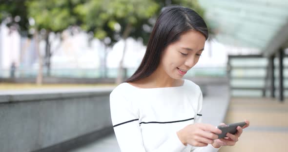 Woman playing cellphone app game at outdoor