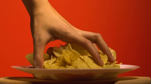 Womans Hand Grabbing Chips From Plate, Home Party With Junk Food, Slow Motion