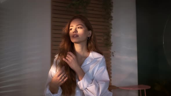 Pretty Red-Haired Girl With Long Hair In White Men's Shirt In The Bathroom.