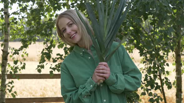 Stylish woman in green shirt with leek