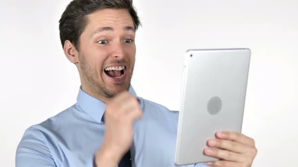 Young Businessman Celebrating Success while Using Tablet on White Background