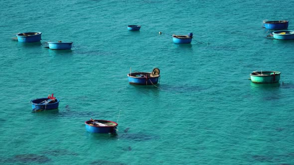 Empty Vietnamese fishing coracle basket boats moored and floating in turquoise Asian sea