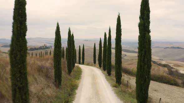 Aerial view passing by of small road crossing mountain countryside, Italy.