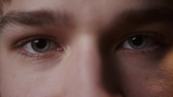 Closeup of Blueeyed Young Man Opening and Closing Eyes Blinking Looking in Camera