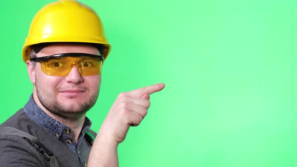 An Engineerassembler Points His Finger to the Side a Portrait of a Worker on of Chromakey