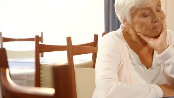 Unhappy senior woman sitting alone