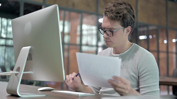 Handsome Guy Working on Document and Computer