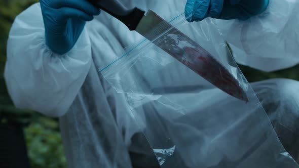 Criminalists Discovering Knife at Crime Scene Closeup Taking Evidence From Accident Murder