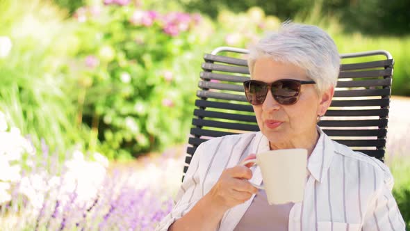 Happy Senior Woman Drinking Coffee at Garden