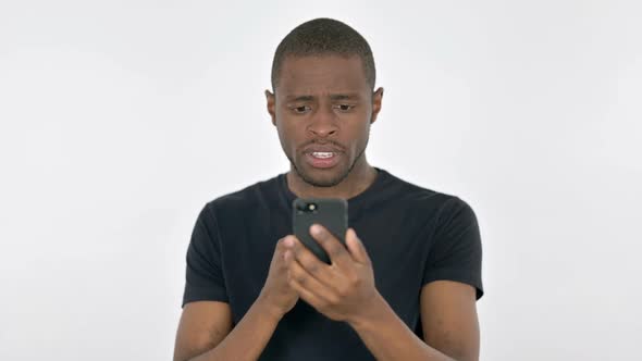 Young African Man Loss on Smartphone on White Background