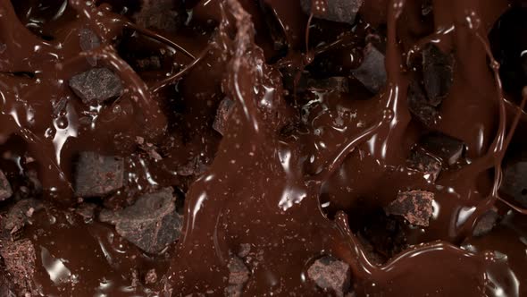 Super Slow Motion Shot of Raw Chocolate Chunks Falling Into Melted Chocolate at 1000 Fps