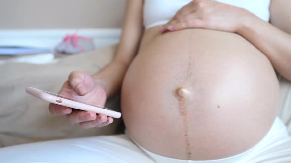 Close Up Of Pregnant Woman Using Mobile Phone