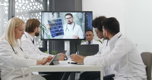 Mixed Race Medical Team which Listening Video Presentation on Digital Whiteboard in Office Room