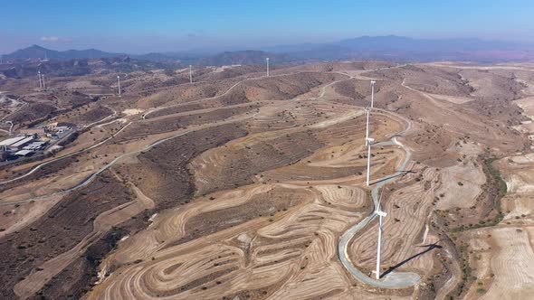 Boundless Fields with Shrubs and Road Against Wind Turbines