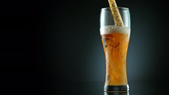 Super Slow Motion Shot of Pouring Fresh Beer Into Glass on Black Background at 1000Fps