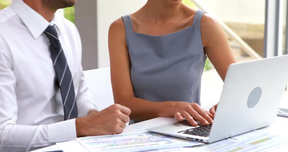 Business executives discussing over laptop 4k