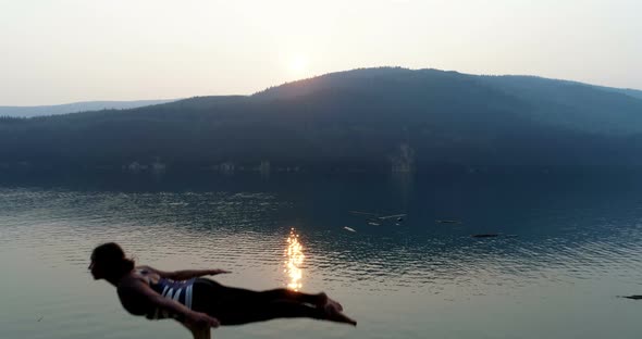 Women practicing acroyoga near lakeside 4k