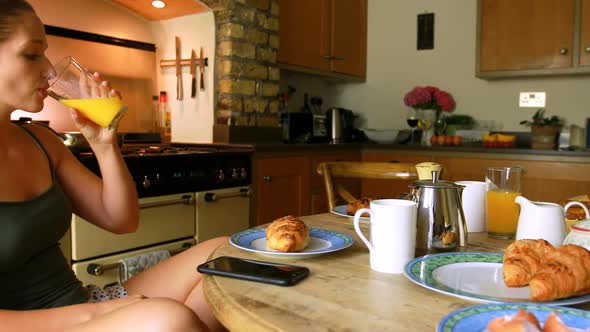 Woman having juice while using mobile phone 4k