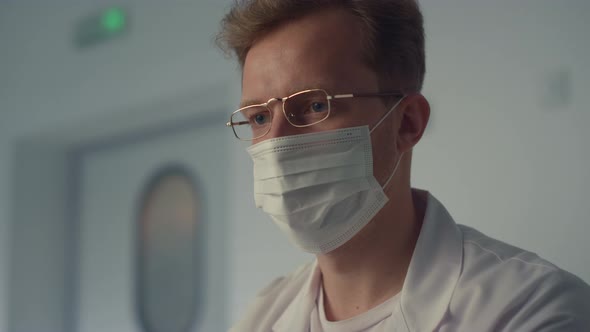 Focused Doctor Writing Notes at Modern Hospital Workplace with Computer