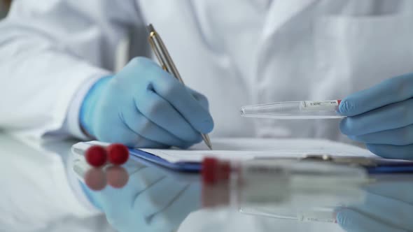 Nurse Inserting Results of Tests for Virus Antibodies Blood Into Card, Epidemic