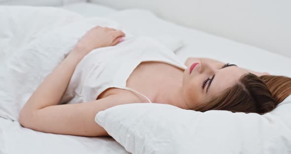 Young Woman Sleeping in Bed, Waking Up in the Morning, Peaceful Woman Is Lying in Bed.
