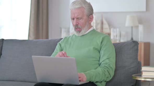 Sick Old Man with Laptop Coughing at Home