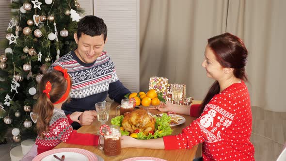 Family Joins Hands and Congratulates for New Year at Supper