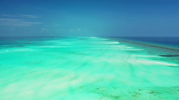 Wide above copy space shot of a white paradise beach and blue water background in colourful 4K