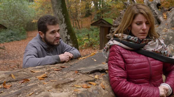 man tries to be forgiven by his sad and angry wife in the park