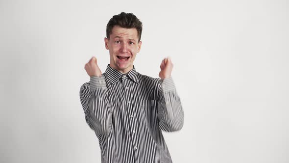 Funny White Guy in a Shirt Grimaces and Winks at the Camera on White Background