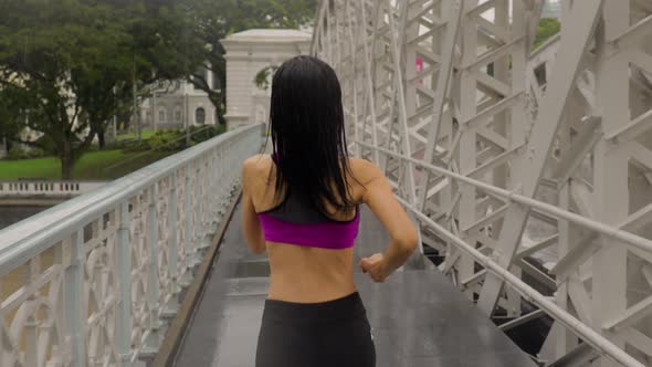 Middle-aged Asian woman jogging in the rain in Singapore 