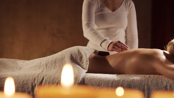 Young, healthy and beautiful woman gets massage therapy in the spa salon.