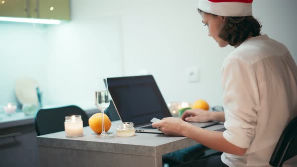 Young Cheerful Woman in Santa Hat Doing Online Shopping Via Internet