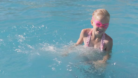 Little Girl Swimming in Swimming Pool Child Having Fun Splashing Water Jumping