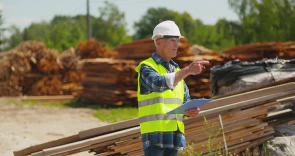 Male Worker Examining Plank's Stack