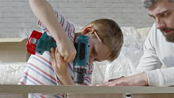 Boy Learning to Use Electric Screwdriver alt