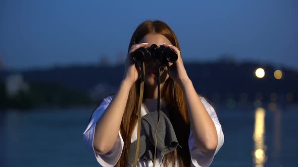 Curious Girl Spending Evening on River Embankment, Looking Through Binoculars