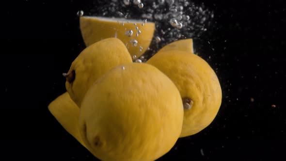 Lemons Falling into Water Super Slowmotion, Black Background, lots of Air Bubbles, 4k240fps