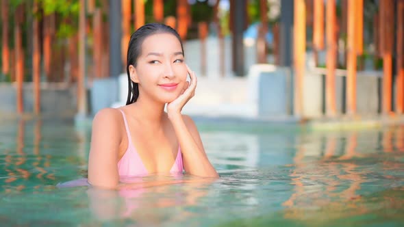 Young asian woman enjoy around outdoor swimming pool for leisure