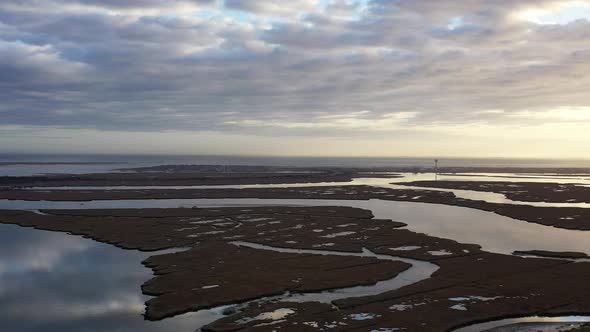 An aerial view over Baldwin Bay near Freeport, NY during sunset. The camera pan & truck left high ov