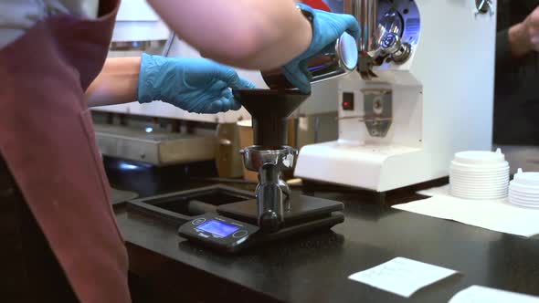 Woman Barista Pours Ground Coffee and Weighs It While Working in Kitchen Spbas